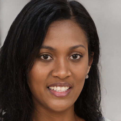 Joyful black young-adult female with long  brown hair and brown eyes