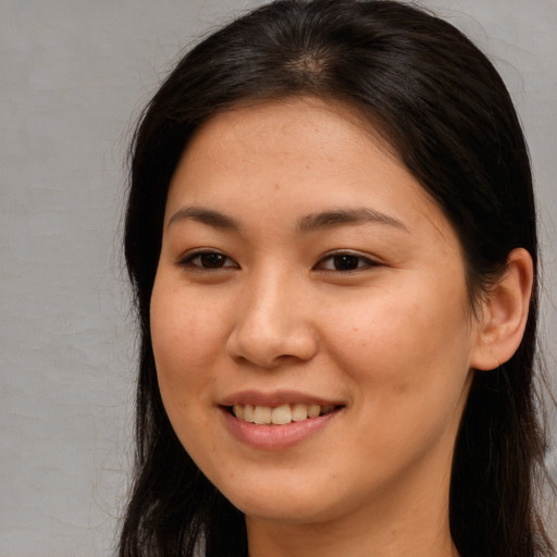 Joyful asian young-adult female with long  brown hair and brown eyes