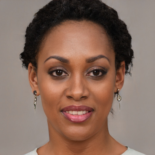 Joyful black young-adult female with short  brown hair and brown eyes