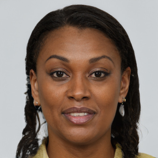 Joyful black adult female with medium  brown hair and brown eyes