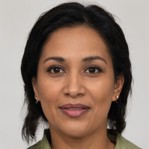 Joyful latino adult female with medium  brown hair and brown eyes