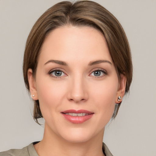 Joyful white young-adult female with medium  brown hair and grey eyes