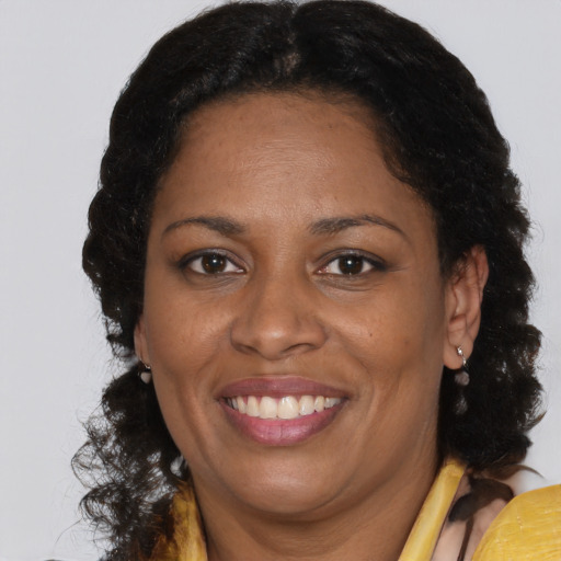 Joyful black adult female with long  brown hair and brown eyes
