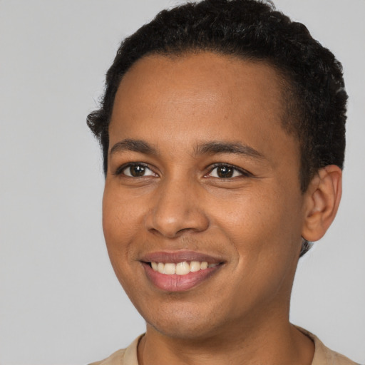 Joyful black young-adult male with short  brown hair and brown eyes