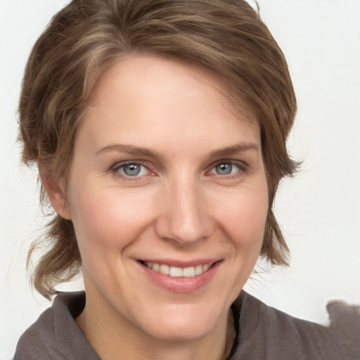 Joyful white adult female with medium  brown hair and grey eyes