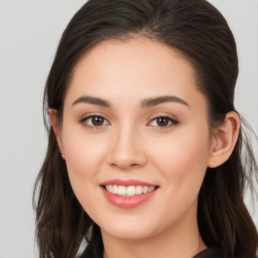 Joyful white young-adult female with long  brown hair and brown eyes