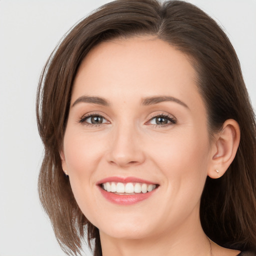 Joyful white young-adult female with long  brown hair and brown eyes