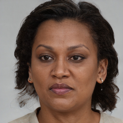 Joyful black adult female with medium  brown hair and brown eyes