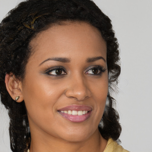 Joyful black young-adult female with long  brown hair and brown eyes
