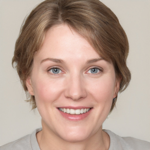 Joyful white adult female with medium  brown hair and blue eyes