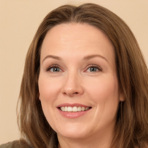 Joyful white adult female with long  brown hair and brown eyes