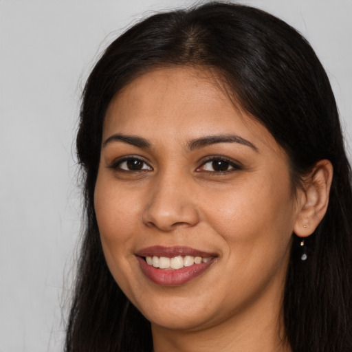 Joyful latino young-adult female with long  brown hair and brown eyes