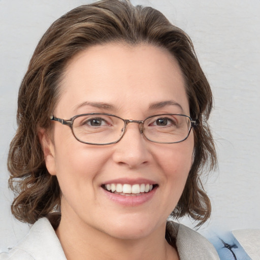 Joyful white adult female with medium  brown hair and blue eyes