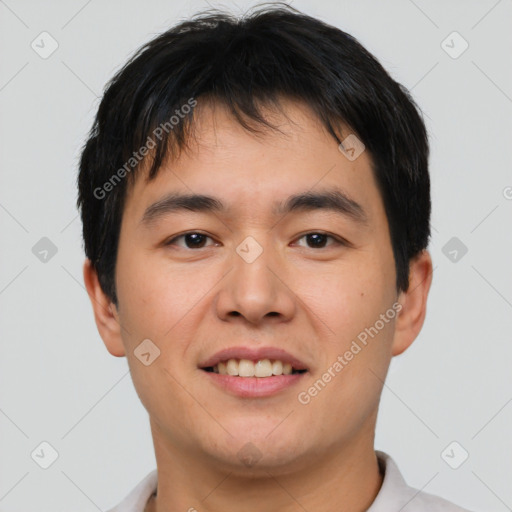 Joyful asian young-adult male with short  brown hair and brown eyes