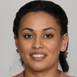 Joyful latino young-adult female with medium  brown hair and brown eyes