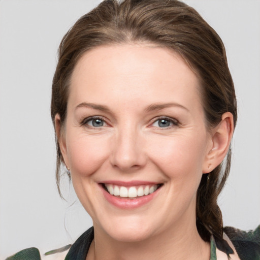 Joyful white young-adult female with medium  brown hair and grey eyes