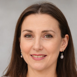 Joyful white adult female with long  brown hair and brown eyes