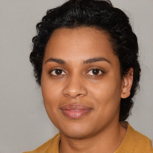 Joyful black young-adult female with long  black hair and brown eyes