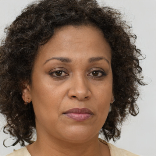 Joyful black adult female with medium  brown hair and brown eyes
