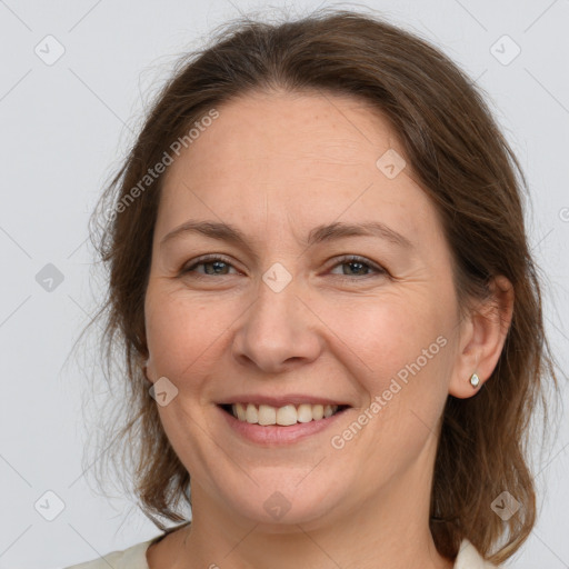 Joyful white adult female with medium  brown hair and grey eyes