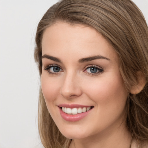 Joyful white young-adult female with long  brown hair and green eyes