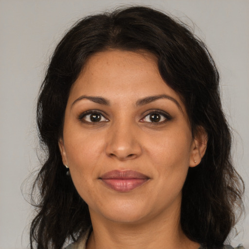 Joyful latino adult female with medium  brown hair and brown eyes