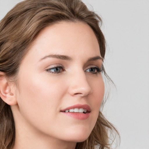 Joyful white young-adult female with long  brown hair and blue eyes