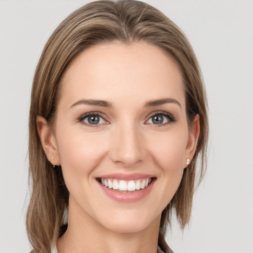 Joyful white young-adult female with medium  brown hair and grey eyes