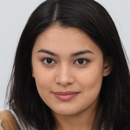 Joyful asian young-adult female with long  brown hair and brown eyes