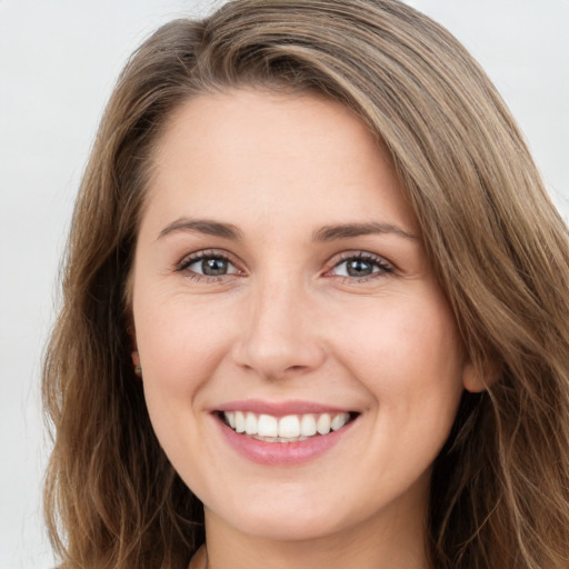 Joyful white young-adult female with long  brown hair and grey eyes