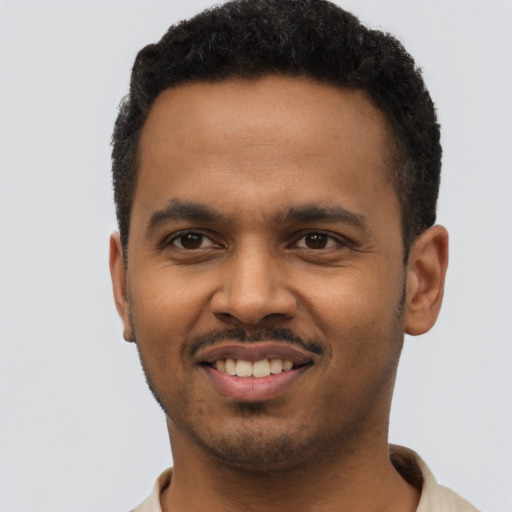 Joyful black young-adult male with short  black hair and brown eyes
