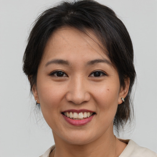 Joyful asian young-adult female with medium  brown hair and brown eyes