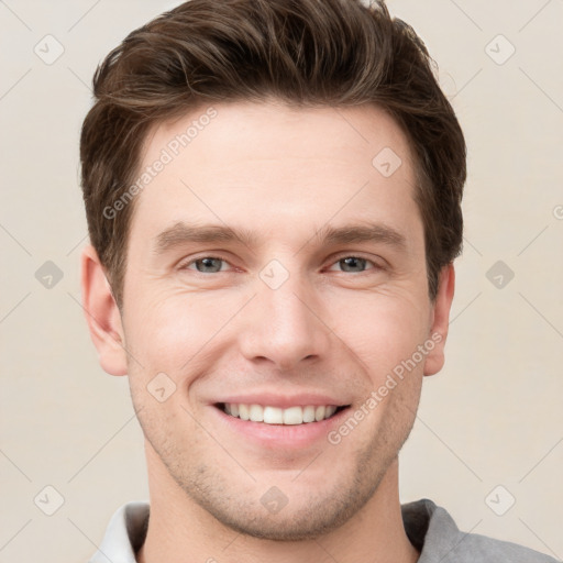 Joyful white young-adult male with short  brown hair and grey eyes