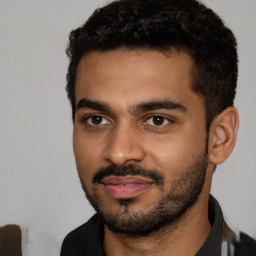 Joyful black young-adult male with short  black hair and brown eyes