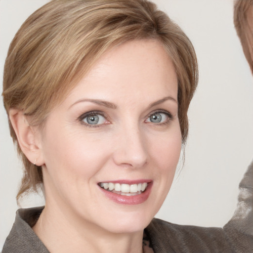 Joyful white young-adult female with medium  brown hair and blue eyes