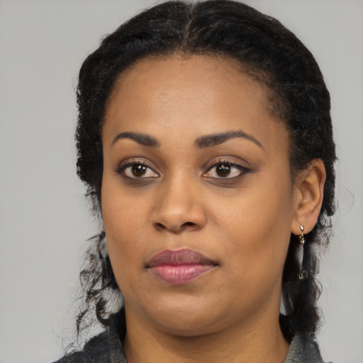 Joyful black young-adult female with long  black hair and brown eyes