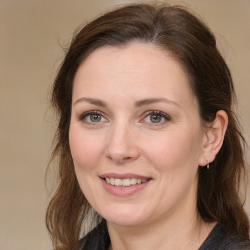 Joyful white adult female with medium  brown hair and grey eyes