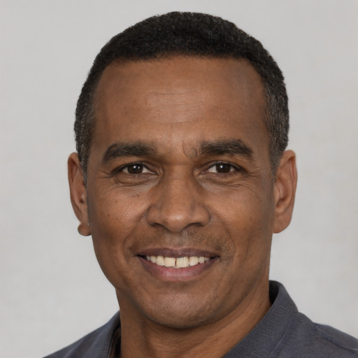Joyful black adult male with short  black hair and brown eyes