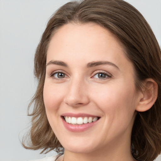 Joyful white young-adult female with medium  brown hair and green eyes