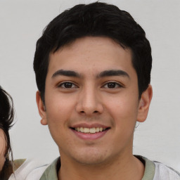 Joyful white young-adult male with short  black hair and brown eyes