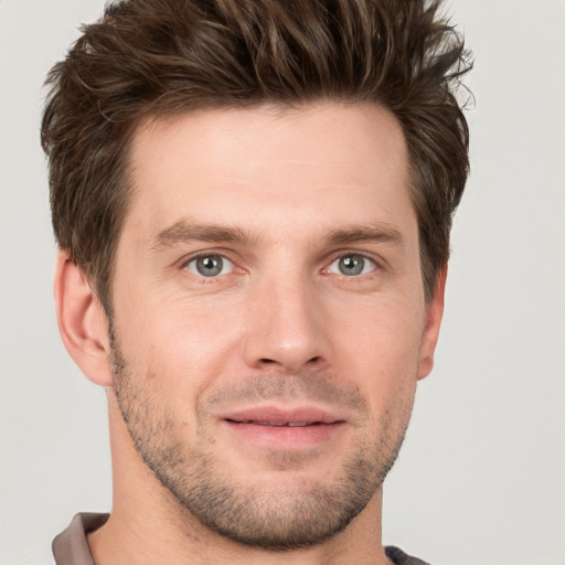 Joyful white young-adult male with short  brown hair and grey eyes