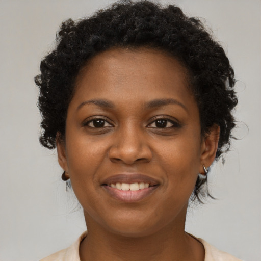 Joyful black young-adult female with short  brown hair and brown eyes