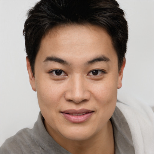 Joyful asian young-adult female with short  brown hair and brown eyes