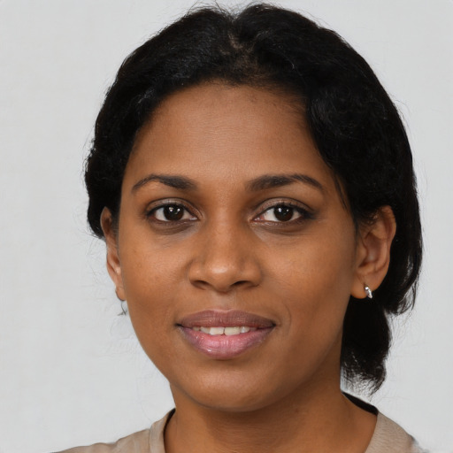 Joyful black young-adult female with medium  black hair and brown eyes