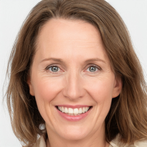 Joyful white adult female with medium  brown hair and grey eyes