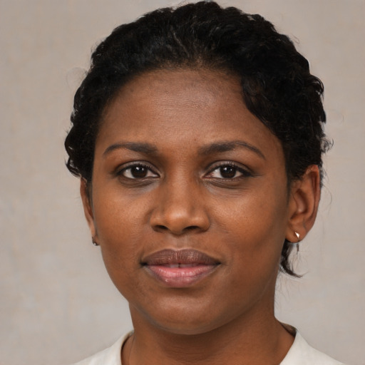 Joyful black adult female with short  brown hair and brown eyes