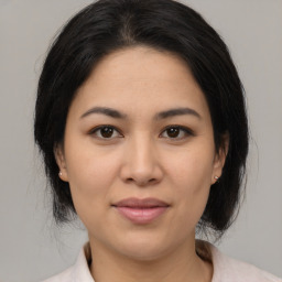 Joyful latino young-adult female with medium  brown hair and brown eyes