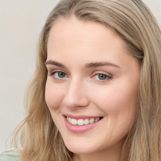 Joyful white young-adult female with long  brown hair and blue eyes