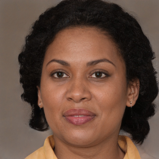 Joyful black adult female with long  brown hair and brown eyes