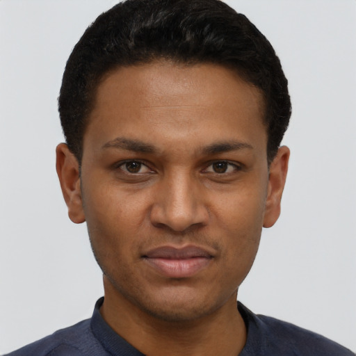 Joyful black young-adult male with short  black hair and brown eyes